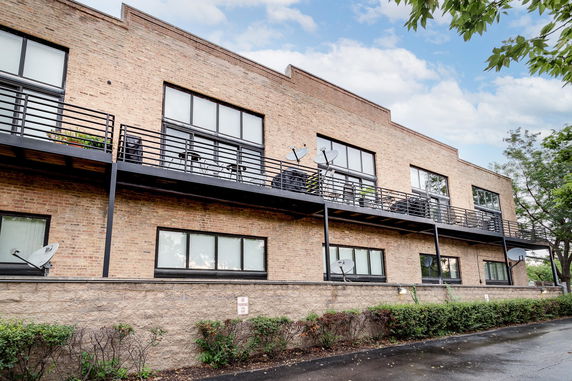 Front view of a multi-story brick building with balconies and windows.