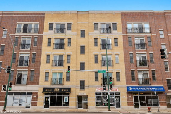 Front view of a multi-story building with shops on the ground floor.