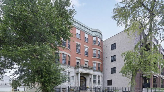 Front view of a multi-story brick building with a formal entrance.