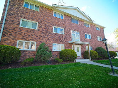 Front view of a three-story brick building with multiple windows and a central entrance.