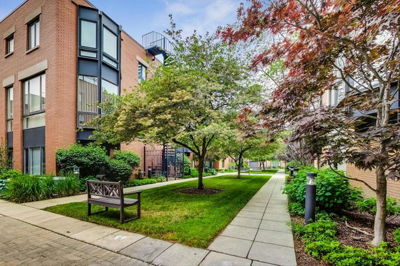 Outdoor view of a residential building with brick facade and landscaped gardens.