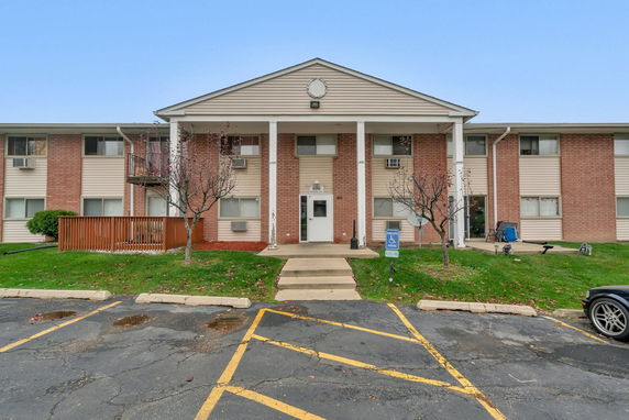 Front view of a two-story brick apartment building with a central entrance.