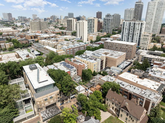 Panoramic view of a cityscape with multiple buildings and highrises under a blue sky.