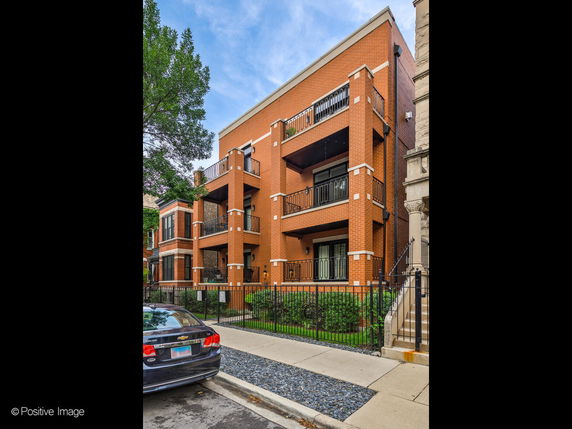 Front view of a multi-story brick building with balconies.