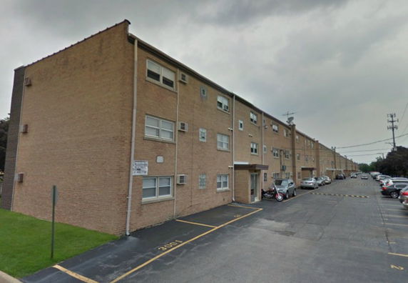 Side view of a multi-story apartment building with brick construction.