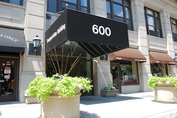 Front view of a commercial building entrance with an awning displaying the number 600.