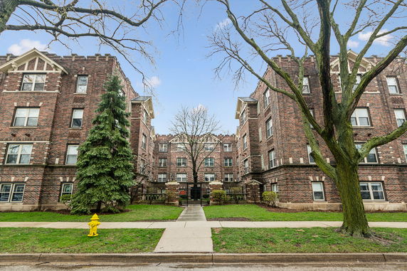 Front view of a multi-story brick building with decorative architectural elements.