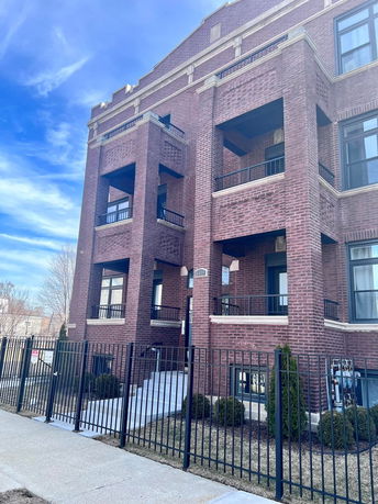 Front view of a multi-story brick building with balconies.