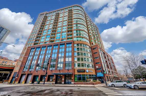 Front view of a multi-story mixed-use building with large windows and balconies.