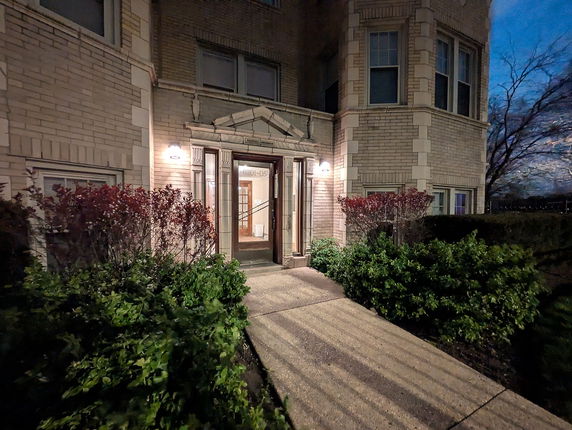 Front view of a multi-story brick building with an entrance walkway.