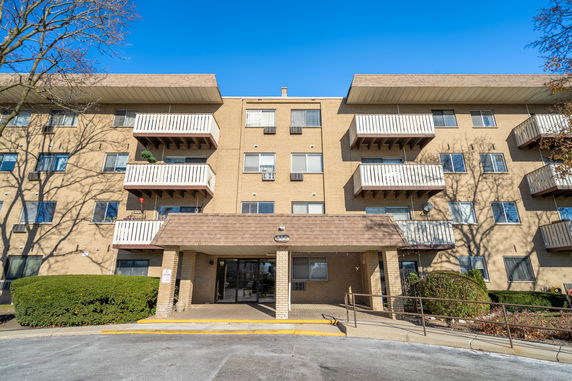 Front view of a multi-story apartment building with balconies.