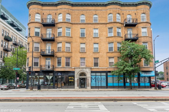 Front view of a multi-story brick building with balconies.