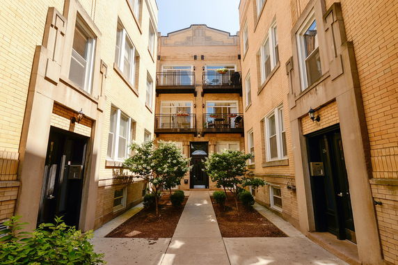 View of apartment building with multiple balconies and entrance area.