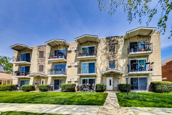 Front view of a three-story apartment building with balconies.
