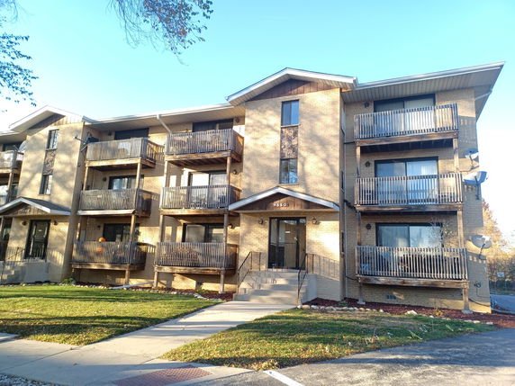 Front view of a three-story apartment building with balconies.