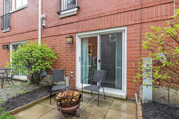 Back view of a brick house with sliding glass doors and patio furniture.