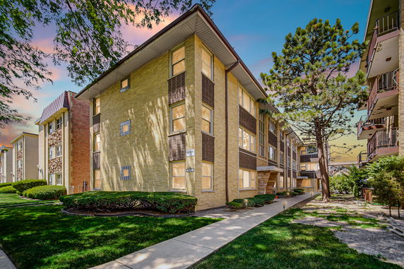 Front view of a multi-story apartment building with brick facade
