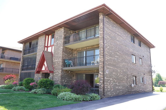 Front view of a multi-story brick building with balconies.
