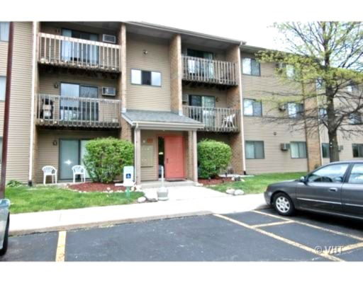 Front view of a multi-story apartment building with balconies and a main entrance.