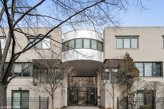 Front view of a modern multi-story building with an archway connecting two sections.