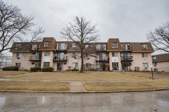 Front view of a three-story apartment building with balconies.