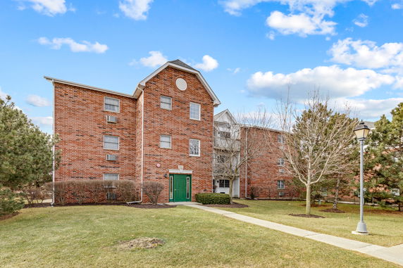 Front view of a multi-story brick building with green door.