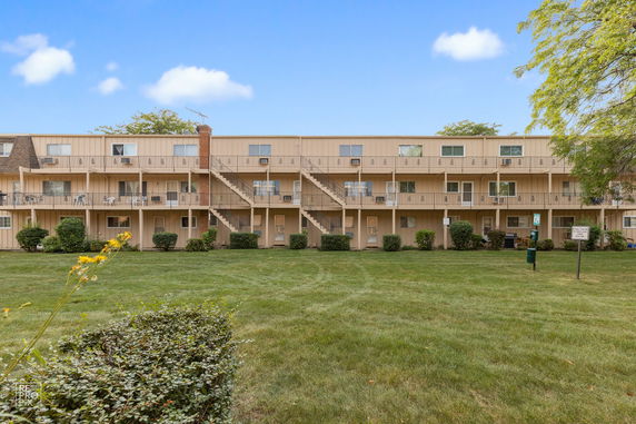 Front view of a three-story apartment building with balconies.