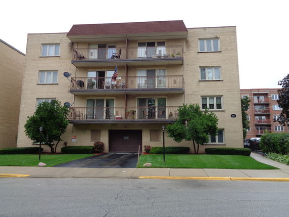 Front view of a multi-story apartment building with balconies.