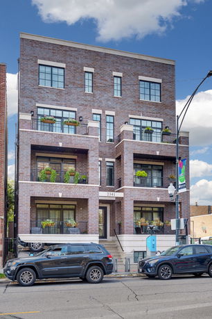 Front view of a multi-story brick building with balconies.