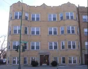 Front view of a multi-story apartment building with multiple windows.