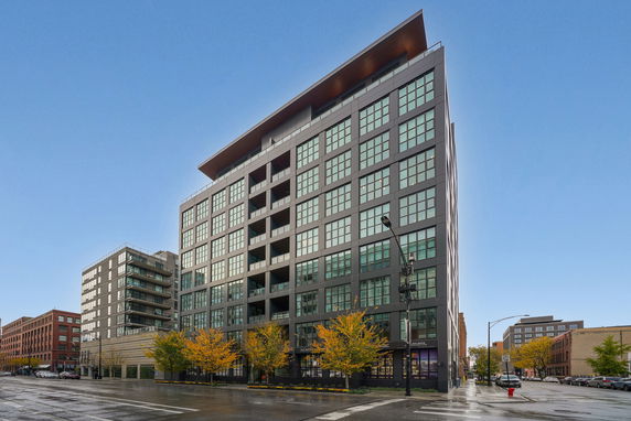 Front view of a multi-story building with large windows and balconies.