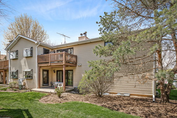 Front view of a two-story house with a balcony and sliding glass doors.