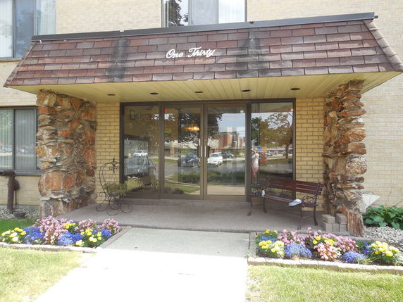 Front view of a building entrance with glass doors and a decorative awning.