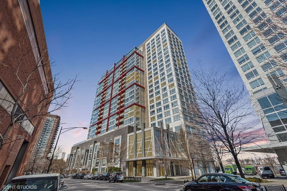 Front view of a modern high-rise building with multiple balconies and large windows.