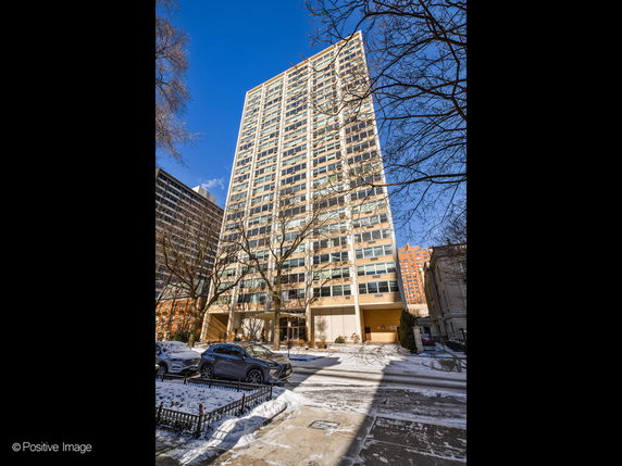 View of a tall multi-story residential building with numerous windows.