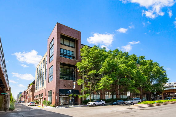 Front view of a multi-story brick building on a corner.