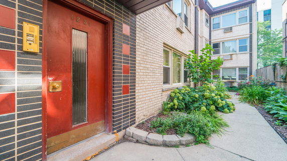 Front view of a building with a red door and brick exterior.