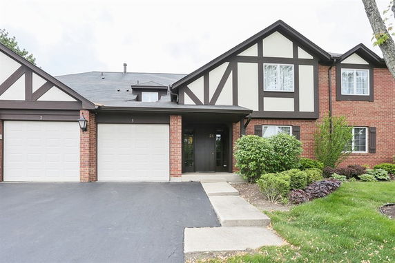 Front view of a two-story house with attached garages and brick facade.