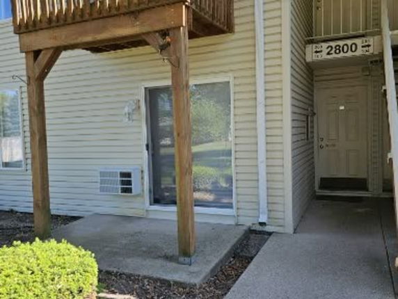 Front view of a building entrance with an upper balcony.