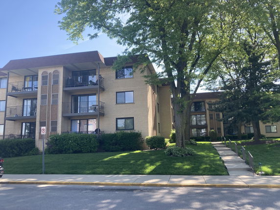 Front view of a multi-story apartment building with balconies.