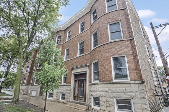 Front view of a multi-story brick building with a decorative entrance.