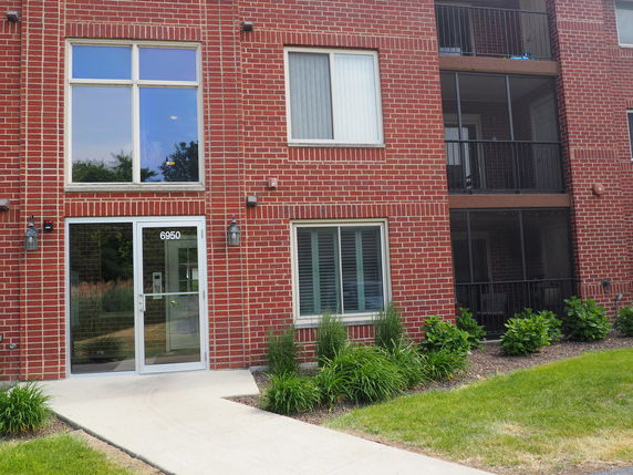 Front view of a red brick building with large windows and a main entrance.