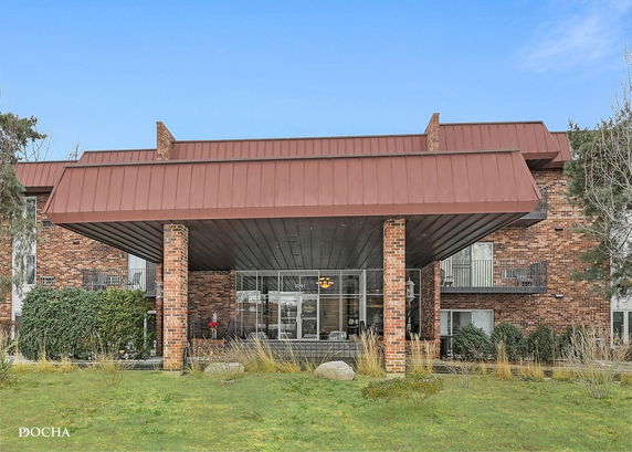 Front view of a brick building with a large covered entrance.