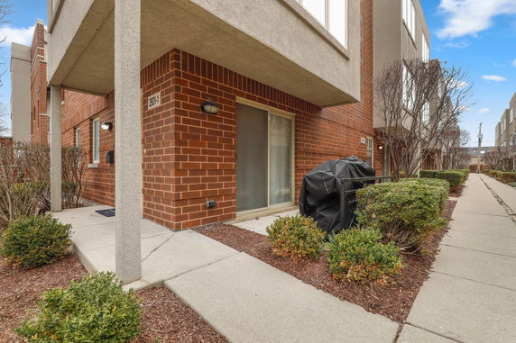 Front view of a brick facade townhouse with a covered entryway.