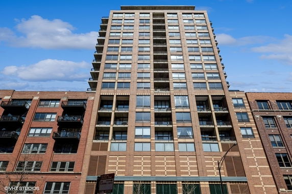 Front view of a multistory apartment building with numerous windows and balconies.