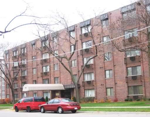 Front view of a multi-story apartment building with brick facade.