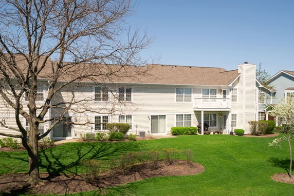 Front view of a two-story residential building with balconies and a sloped roof.