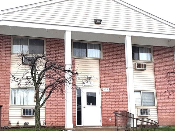 Front view of a two-story apartment building with brick and siding exterior.