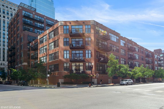 Front view of a multi-story brick building with large windows and balconies.