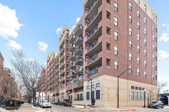 Front view of a multi-story apartment building with balconies.